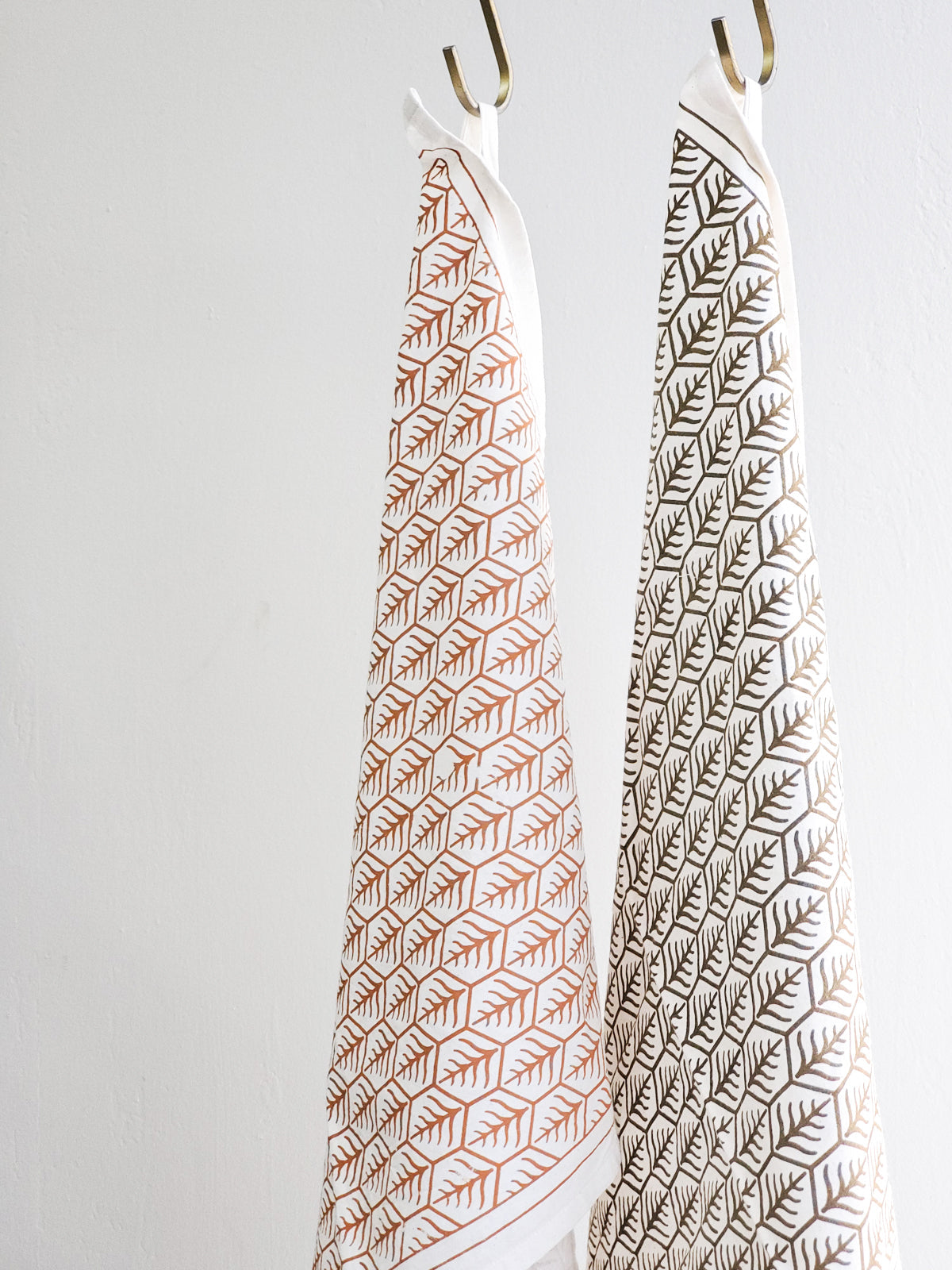 Hanging printed tea towels with closeup of Korissa label 