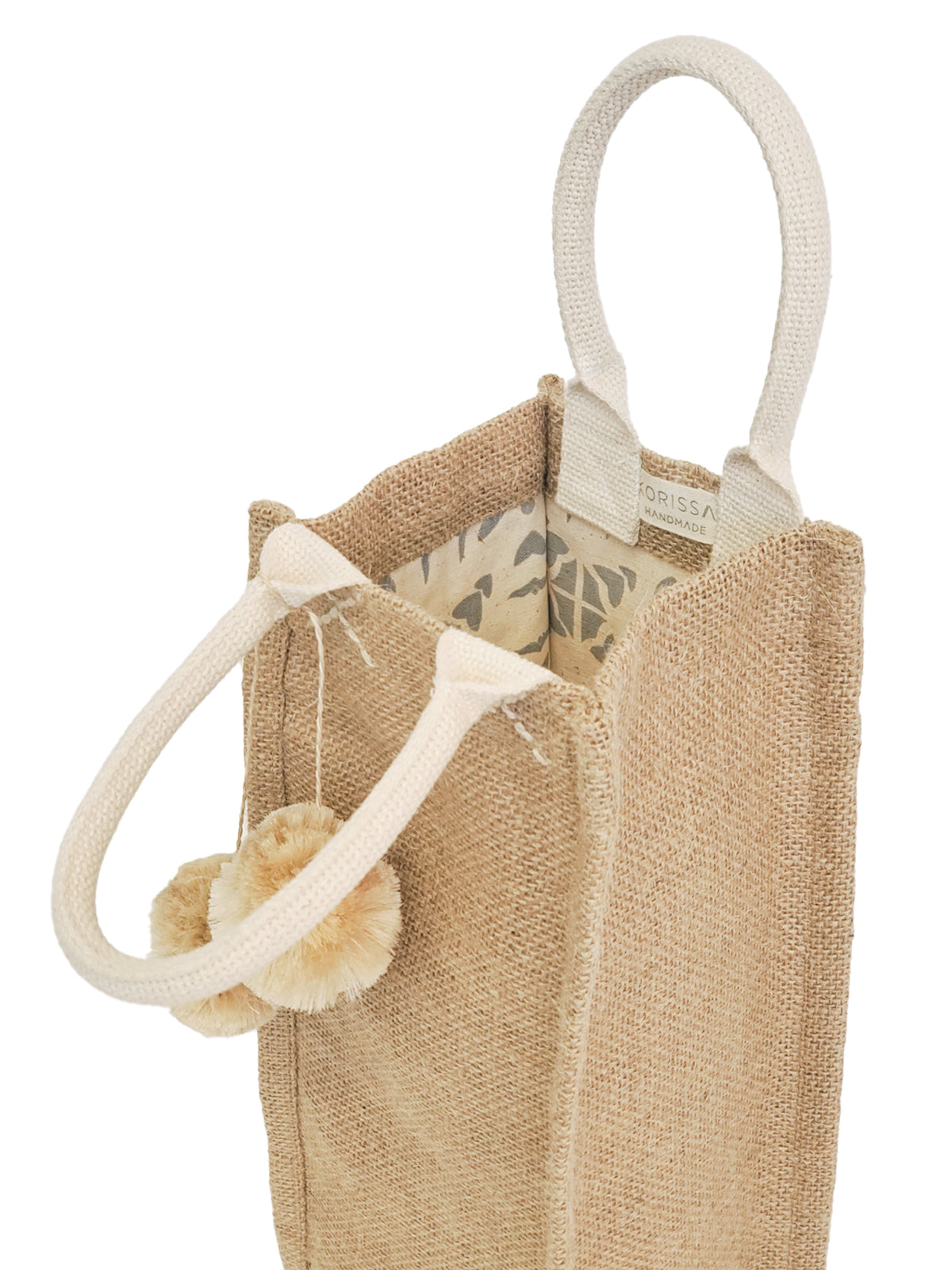 Closeup of handles of pompom canvas wine bag