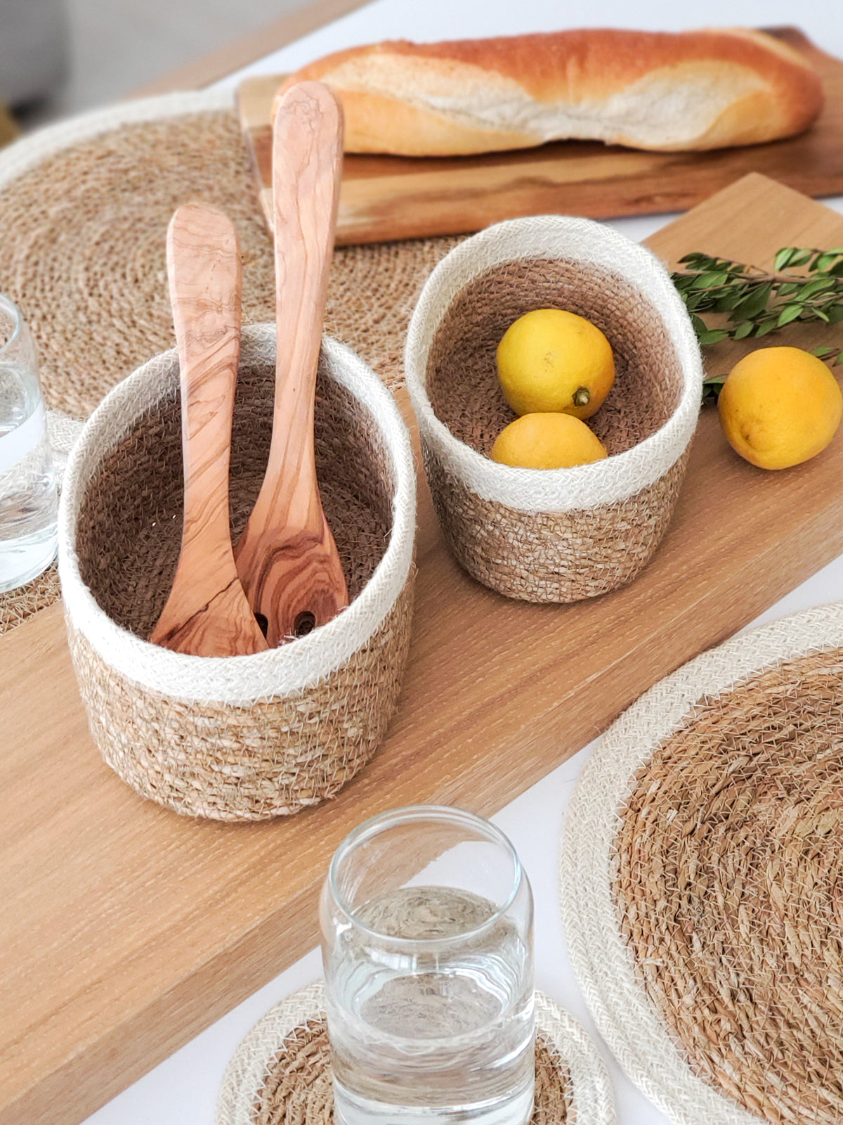 oval seagrass storage baskets styled on a table with utensils and fruit